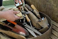 Garden hand tools being oiled in early spring, Norfolk, UK, March 