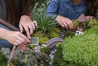 Miniature Wheelbarrow Garden. Adding an animal figurine and an artificial vegetable plot to the miniature garden