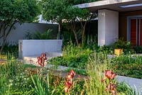 Garden of Mindful Living, a contemporary garden with limestone rill, block and corten steel walls, nulti-stemmed trees and planting of Alchemilla, Aquilegia 'White Barlow', Blechnum tabulare, Digitalis 'Dalmation White', Epimedium, Geum 'Cooky', Hakonechloa, Matteuccia struthiopteris, Melica altissima and Luzula. The RHS Chelsea Flower Show 2016 - Designer: Paul Martin - Sponsor: Vestra Wealth LLP - GOLD