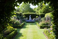 Formal rose garden enclosed by a Beech hedge, with Box borders and a stone statue, with Roses 'Sissinghurst Castle', 'Charles de Mills', 'Mary Rose', 'Munstead Wood', 'The Pilgrim', 'Fantin Latour', Rosa gallica var. officinalis, 'William Lobb', Rosa 'Complicata'