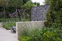 Secluded seating area hidden behind a wall and tall Verbena bonariensis stems
