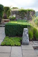 Contemporary country garden, with Box squares, stone paving, ornamental grasses Molinia caerulea ssp. caerulea 'Heidebraut', pots planted with Cosmos 'Purity'