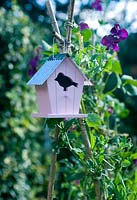 Decorative pink bird house with sweet peas