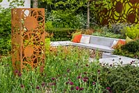 Decorative panels by Natasha Webb surrounded by Tiarella cordifolia, Taxus baccata, Cirsium rivulare 'Atropurpurea', The Sunken Retreat, RHS Malvern Spring Festival 2016. Design: Ann Walker, Graduate Gardeners