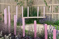 Pink painted wooden posts and attached seat giving a floating effect. Hidden Message, RHS Tatton Flower Show 2011, Cheshire