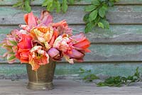 Bunch of Tulipa 'Malaika', 'Temple of Beauty', 'Floriosa' and 'Apricot Parrot' in a brass bucket