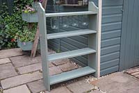 Upcycled book shelves with glass jar storage attached to a shelf