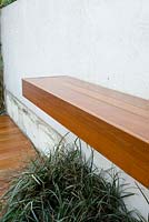 Shelf made from decking planks in small urban garden