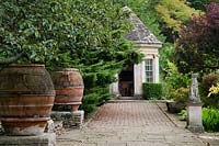 Cobblestone path leading up to the 18th century Garden House past large terracotta urns