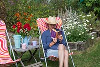 A woman reading a book relaxing in a refurbished deck chair