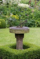 A sundial surrounded by box topiary.