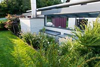 Modern pavillon in formal garden, backside boarder with Pennisetum alopecuroides