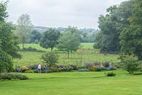 Visitors to Coton Manor inspecting the blue and orange Meadow Border.