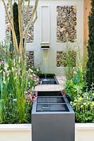 A Suffolk Retreat. Water trough flanked by perennials, Iris 'Jane Philips' and yew. Sponsor: The Pro Corda Trust. Designer: Freddy Whyte. RHS Chelsea Flower Show 2016