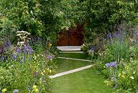 A grass path criss-crossed with stone paving between colour themed borders. A Dog's Life, designed by Paul Hervey-Brookes.