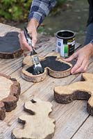Coat the Oak tree slices with blackboard paint