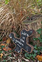 Oak tree slice painted and decorated to display 'We're in the garden'