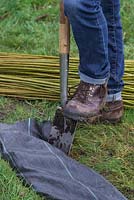 Use the spade to tuck in and secure the weed control fabric