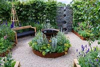 CCLA. A summer Retreat. Circular bed with shallow water basin and rusty steel edging. Bespoke timber bench, gravel pathway. Designers: Amanda Waring and Laura Arison. Sponsors: CCLA. RHS Hampton Court Palace Flower Show 2016