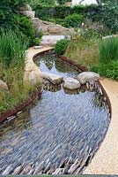 The WWT Working Wetlands Garden. Water channel bed with vertical slate pieces for filtration of water. Designer: Jeni Cairns, Sponsors: WWT. RHS Hampton Court Palace Flower Show 2016