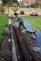 Stepped border in London garden - builder putting  cement into trenches for foundations