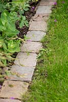 Stone setts used as lawn edging to allow use of lawn mower next to border