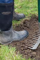 Stand on the surface to compress and compact  the soil 