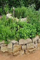 Herb spiral made of stones with Satureja montana, Origanum vulgare and Rosmarinus officinalis. 'Le jardin qui se savoure' designed by Guillaume Popineau, David Trigolet and Chantal Dufour at the Festival International des Jardins 2016, Chaumont-sur-Loire, France