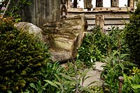 Weathered wooden seat with naturalistic planting and stepping stones - Macmillan Legacy Garden - RHS Malvern Spring Show 2016