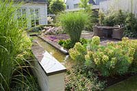 Rectangular pond and terrace. Borders with Euphorbia characias, Miscanthus sinensis and Thymus.