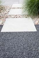 Paving with stepping stones, pebbles and grey split.
