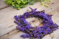 A purple Salvia wreath on a wooden surface
