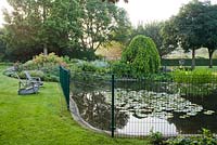 Recliners by the pond with fsmall children safe fence. Yvan and Gert garden In Belgium.