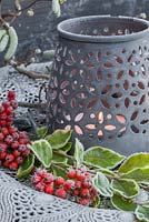 Silver platter containing frosted Cotoneaster berries and a lit candle jar