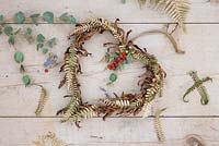 A wreath made with gold spray painted Fern foliage, dead fern foliage, Eucalyptus and Ilex verticillata