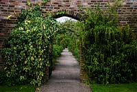 Gateway in brick wall leading to walled garden, Arley Hall Gardens, Cheshire