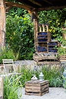 Rustic style sitting area with chairs and crate as a table surrounded by Lavender garden. The Lavender Garden, Designers: Paula Napper, Sara Warren, Donna King. Sponsor: Shropshire Lavender. RHS Hampton Court Flower Show 2016