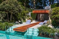 Luxury garden with sun terrace, waterfall and swimming pool. Contemporary sculptured lilac sun loungers and the roof planted with lavender 