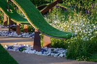 Corten Steel water bawl and waves of turf over white stones, Agastache 'Black Adder' and Leucanthemum vulgare - The World Vision Garden, RHS Hampton Court Palace Flower Show 2016