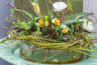Spring flower arrangement in a glass bowl with Ranunculus asiaticus and Tulipa