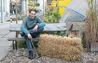 The dutch designer Paul van Hedel sitting on a straw bale.