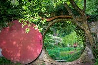 The  moon gate, opening onto the Chinese section of the Rhododendron garden with Weeping Willow and Cornus controversa 'Variegata' 