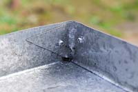 Detail of a corner of the sheet of metal secured together with rivets