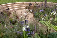 seating area amid wildflower planting in the All the World's A Stage Garden, Hampton Court Palace Flower Show 2016 