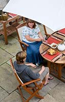 Gill Pritchard with friend enjoying glass of wine at patio table