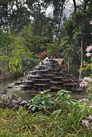 Decorative fountain of stepped flat stones in tropical gardens with duck house behind - Lake Atitlan Hotel, Guatemala