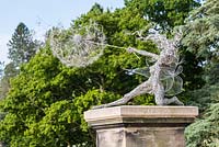 A life sized fairy, called 'Wishes' stands on a plinth beside the lake at Trentham Gardens, Staffordshire. it commemorates the first ten years of the garden's regeneration. The artwork was created by Robin Wight from galvanised and stainless steel wire