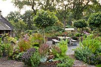 Late summer garden with perennial borders and relaxing area on a paved patio. Design: Luc and Petra ter Beek