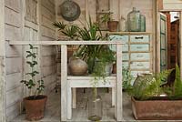 Open-sided wooden shed with potted plants and decorative features