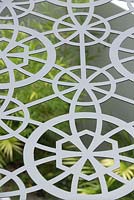 Detail of a metal laser cut pergola roof with a geometric pattern.